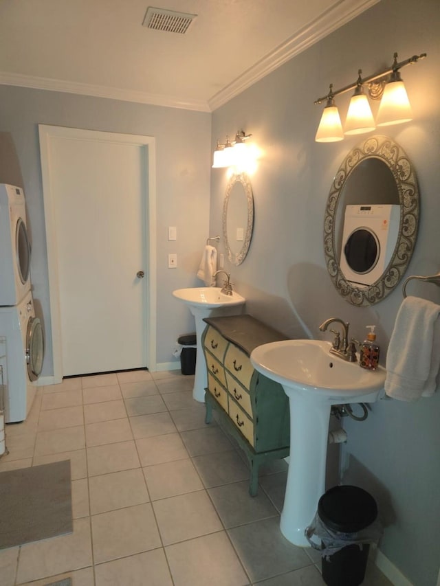 bathroom with tile patterned floors, double sink, ornamental molding, and stacked washer and dryer