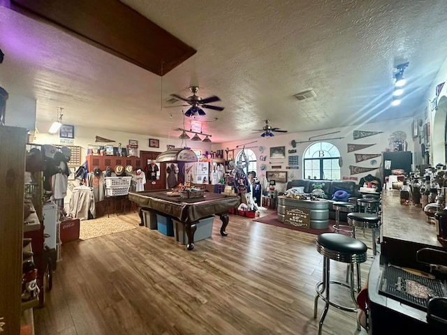 recreation room featuring ceiling fan, pool table, a textured ceiling, and hardwood / wood-style flooring