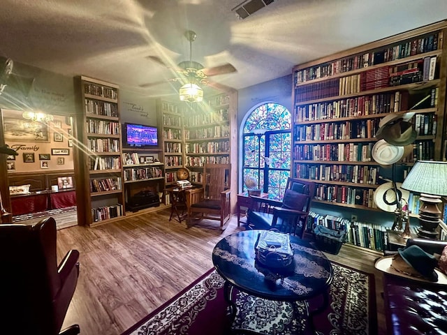 sitting room featuring a textured ceiling, ceiling fan, and wood-type flooring