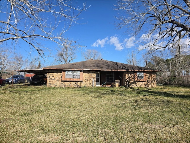 back of property with a lawn and a carport