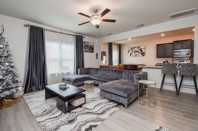 living room featuring ceiling fan and light wood-type flooring