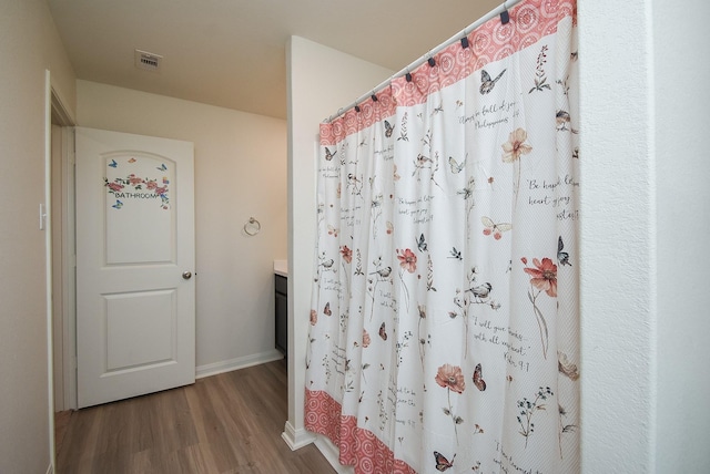 bathroom with curtained shower, wood-type flooring, and vanity