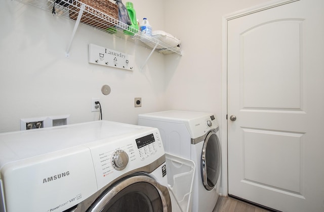 laundry area featuring washer and clothes dryer and hardwood / wood-style floors