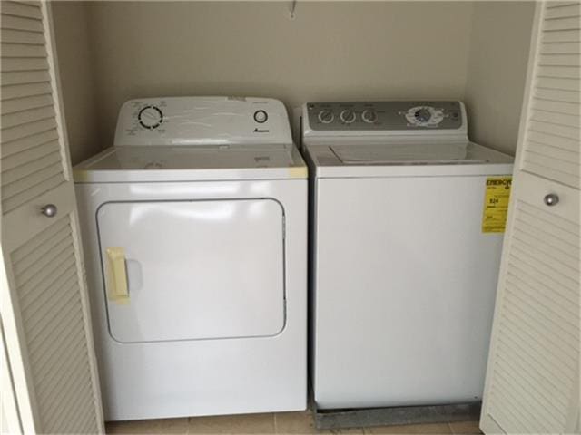 washroom with laundry area, washing machine and dryer, and tile patterned floors