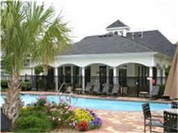 pool with a patio area, fence, and an outbuilding