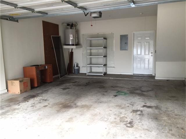 garage featuring water heater, electric panel, and a garage door opener