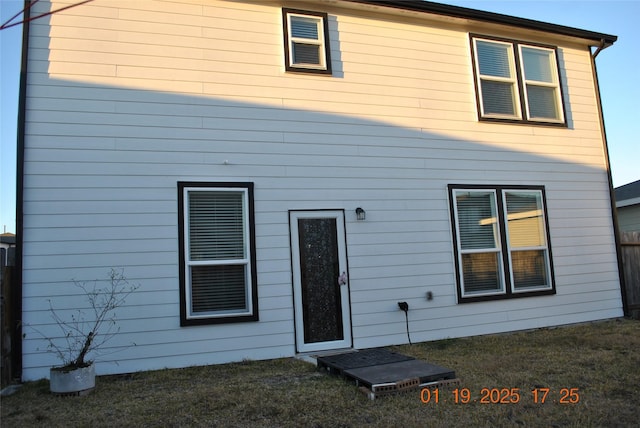 rear view of property with a lawn