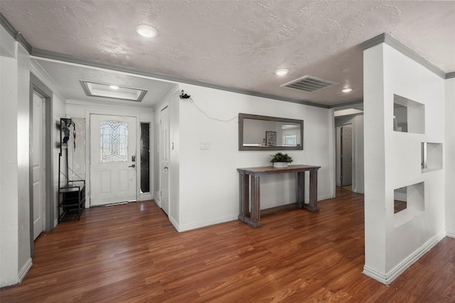 foyer entrance featuring a textured ceiling, dark wood-type flooring, and ornamental molding