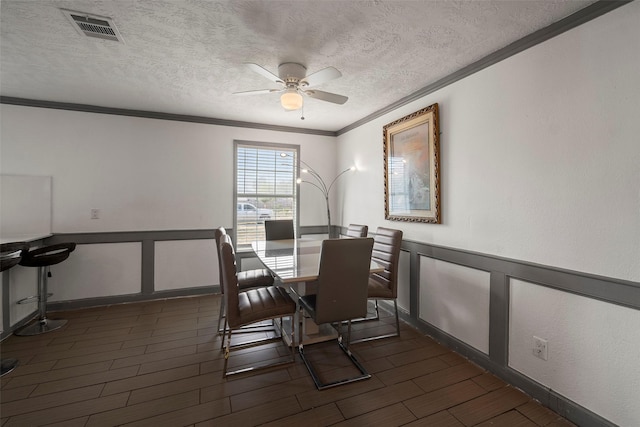 dining room with ceiling fan, crown molding, and a textured ceiling