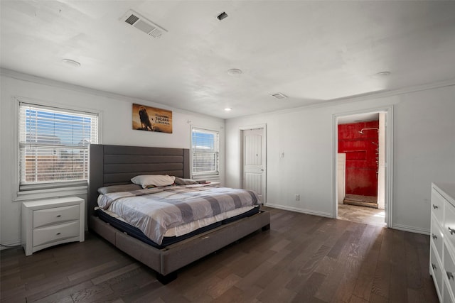 bedroom with multiple windows, dark hardwood / wood-style floors, and ensuite bath