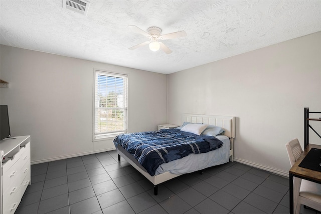 tiled bedroom with ceiling fan and a textured ceiling