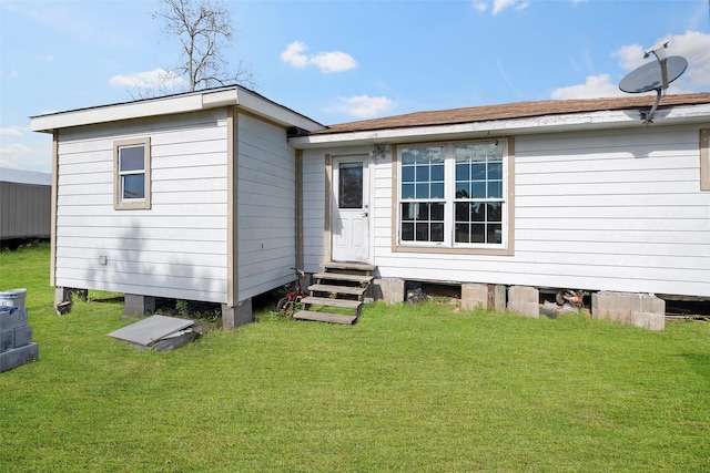 rear view of property featuring a lawn