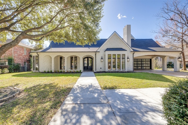 french country style house featuring a front lawn and a carport