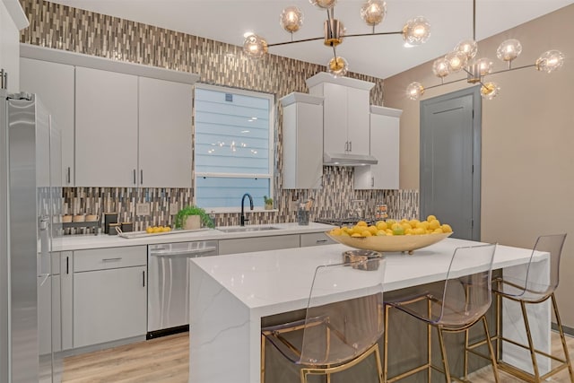 kitchen with decorative light fixtures, tasteful backsplash, sink, appliances with stainless steel finishes, and white cabinets