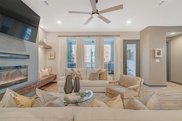 living room with ceiling fan and light hardwood / wood-style flooring