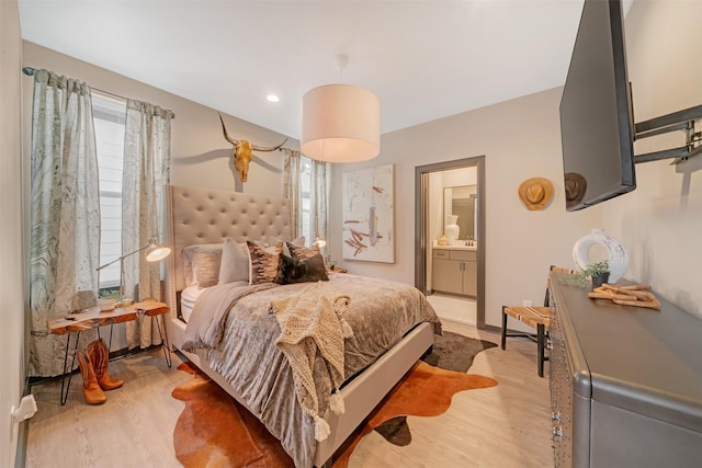 bedroom featuring ensuite bathroom and light hardwood / wood-style flooring