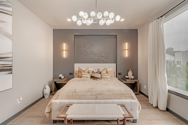 bedroom featuring light hardwood / wood-style floors and a chandelier