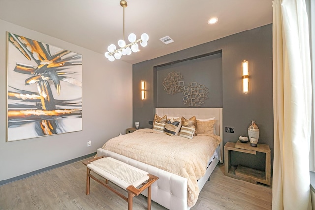 bedroom with hardwood / wood-style floors and a notable chandelier