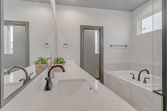 bathroom with vanity and tiled tub