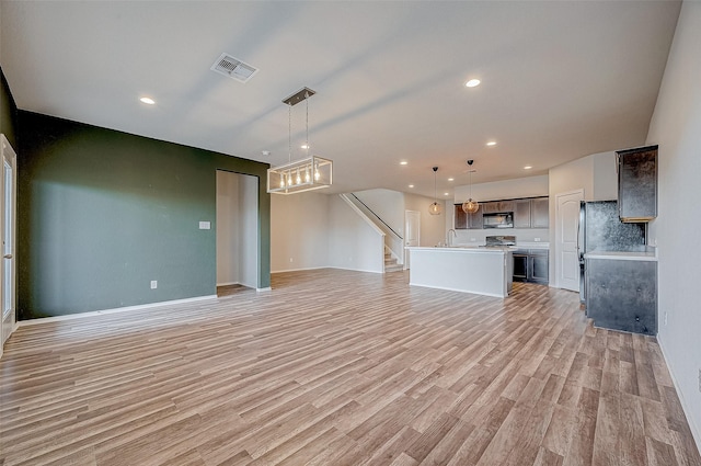 unfurnished living room with sink and light hardwood / wood-style flooring