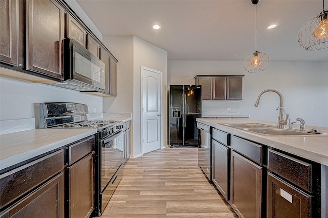 kitchen featuring decorative light fixtures, black appliances, sink, light hardwood / wood-style flooring, and dark brown cabinetry