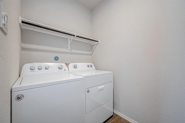 laundry area featuring dark wood-type flooring and washer and clothes dryer