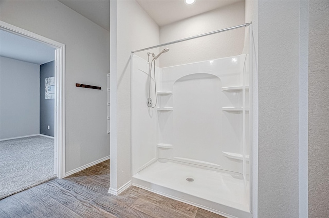 bathroom with wood-type flooring and walk in shower