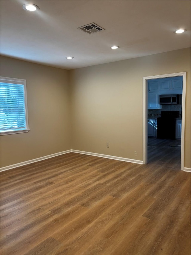 unfurnished room with dark hardwood / wood-style floors