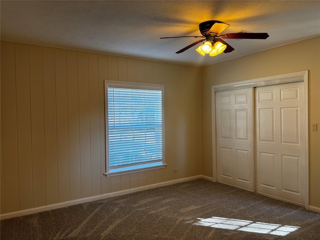 unfurnished bedroom with ceiling fan, a closet, carpet floors, and multiple windows