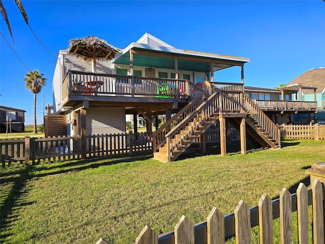 rear view of property with a wooden deck and a yard