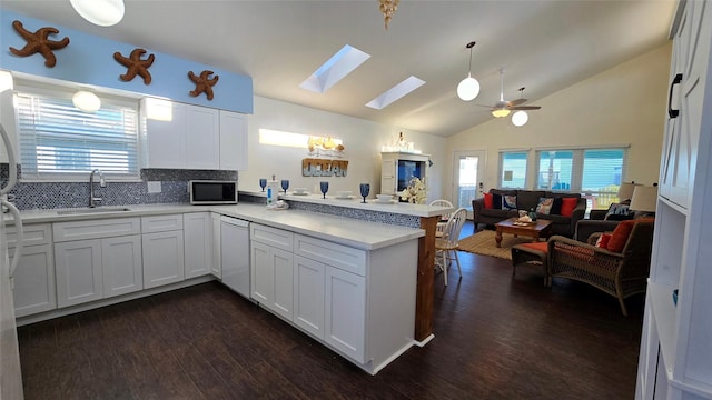 kitchen featuring dishwasher, white cabinetry, sink, backsplash, and kitchen peninsula