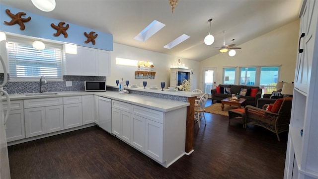 12929 John Reynolds Rd, Galveston, TX 77554 - kitchen featuring white dishwasher, a sink, open floor plan, stainless steel microwave, and a peninsula