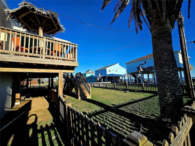 12929 John Reynolds Rd, Galveston, TX 77554 - view of yard with stairway, a wooden deck, and a fenced backyard
