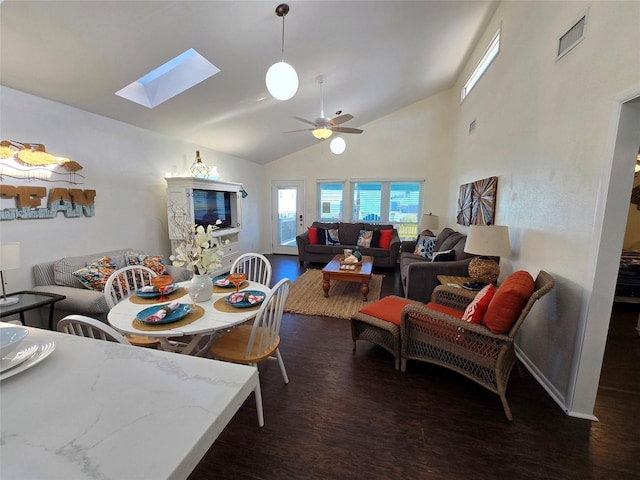 dining room featuring dark hardwood / wood-style flooring, lofted ceiling with skylight, and ceiling fan