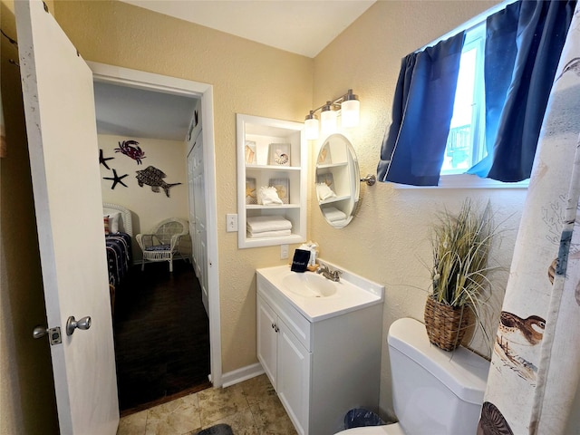 12929 John Reynolds Rd, Galveston, TX 77554 - bathroom with a textured wall, vanity, connected bathroom, and toilet