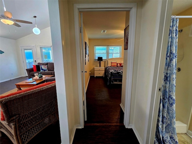 12929 John Reynolds Rd, Galveston, TX 77554 - hallway with vaulted ceiling, baseboards, wood finished floors, and visible vents