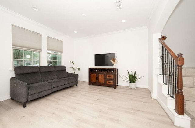 living room featuring ornamental molding and light hardwood / wood-style flooring