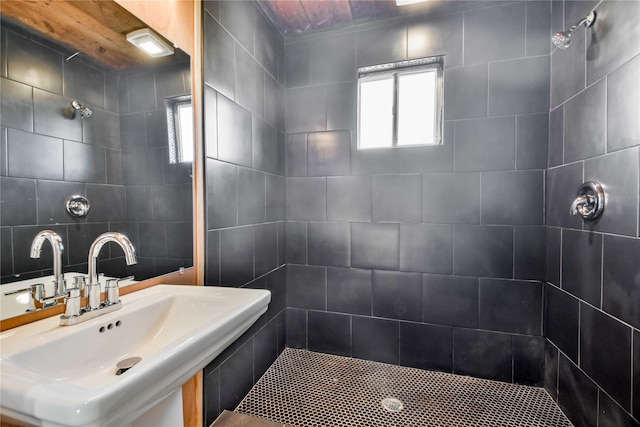 bathroom featuring tiled shower and sink