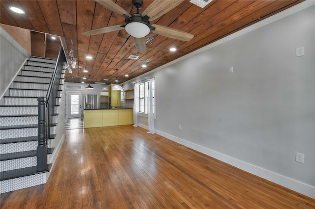 unfurnished living room with ceiling fan, a wealth of natural light, wood-type flooring, and wooden ceiling