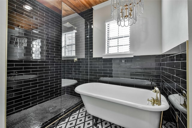 bathroom with independent shower and bath, a chandelier, tile walls, and tile patterned flooring