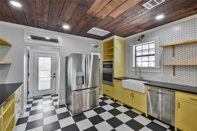 kitchen with appliances with stainless steel finishes, wood ceiling, tasteful backsplash, sink, and ornamental molding