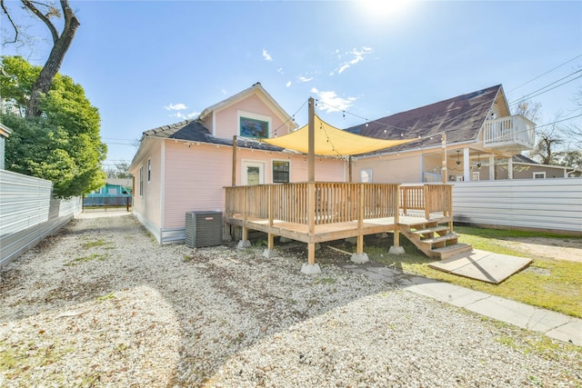 rear view of house with a deck and central AC