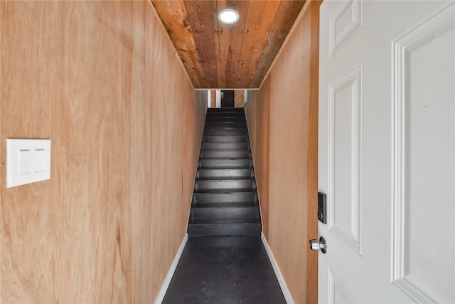 stairs featuring wood walls and wooden ceiling