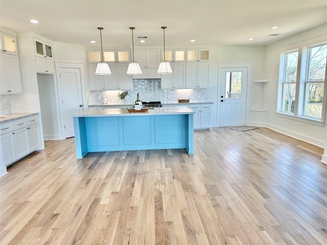 kitchen with pendant lighting, light hardwood / wood-style floors, and white cabinets