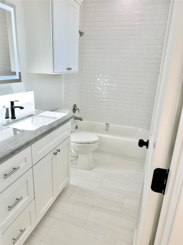 full bathroom with toilet, tile patterned flooring, tiled shower / bath combo, and vanity