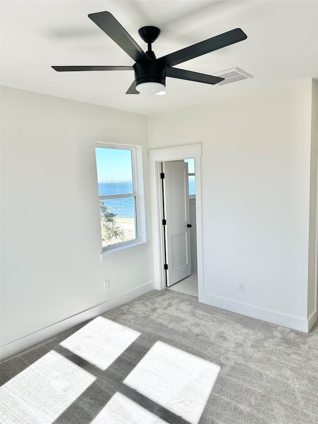 carpeted empty room featuring ceiling fan