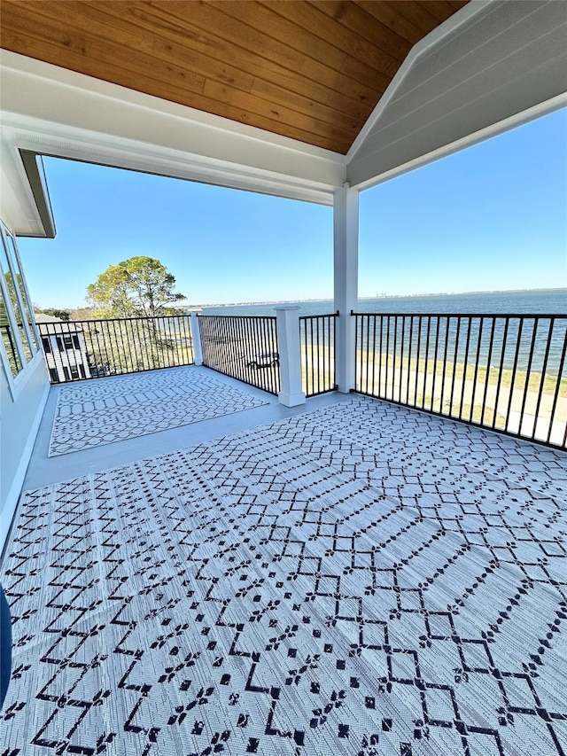 wooden deck featuring a beach view and a water view