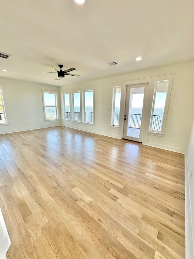 unfurnished living room with ceiling fan and light hardwood / wood-style flooring