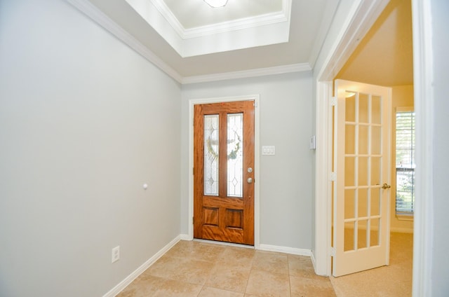 foyer entrance with a raised ceiling, crown molding, and light tile patterned floors