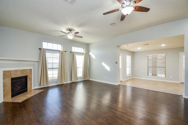 unfurnished living room with ceiling fan, hardwood / wood-style floors, and a fireplace